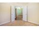 Bedroom entry with white doors and trim, carpet flooring, and view to the living area with hardwood flooring at 264 La Patos Dr., Myrtle Beach, SC 29588