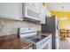 Kitchen features white cabinets, stainless steel refrigerator, and mosaic tile backsplash at 264 La Patos Dr., Myrtle Beach, SC 29588