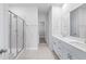 Bathroom boasts double vanity, large mirror, and tiled shower with glass door at 2700 Tranquility Loop, Longs, SC 29568