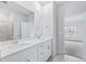Modern bathroom with double vanity, large mirror, and doorway to carpeted bedroom at 2700 Tranquility Loop, Longs, SC 29568