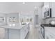 Bright kitchen with island, stainless steel appliances, and access to pantry and laundry area at 2700 Tranquility Loop, Longs, SC 29568