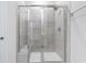 Modern shower with glass doors, showerhead, bench, and tiled walls at 2700 Tranquility Loop, Longs, SC 29568