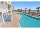 This outdoor swimming pool has blue lounge chairs and tropical palm trees at 2801 S Ocean Blvd. # 941, North Myrtle Beach, SC 29582