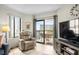 Bright living room featuring a recliner, TV, and balcony access with outdoor seating at 310 73Rd Ave. N # 5B, Myrtle Beach, SC 29572