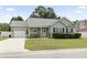 Inviting one-story home featuring a well-kept lawn, flower beds, and a charming entrance at 3468 Trailside Dr., Little River, SC 29566