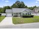 Charming single-story home with well-maintained landscaping, a driveway and an American flag at 3468 Trailside Dr., Little River, SC 29566