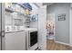 Functional laundry room with modern washer and dryer, shelving, and access to a bathroom at 3468 Trailside Dr., Little River, SC 29566
