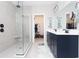Bathroom featuring a tiled walk-in shower, double vanity with dark cabinets, and walk in closet at 383 Mikita Dr., Surfside Beach, SC 29575