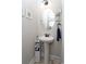 Chic half-bathroom showcasing a pedestal sink, an oval mirror, and decorative shelving at 383 Mikita Dr., Surfside Beach, SC 29575