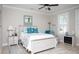 Cozy bedroom featuring a white bed with blue accents, complemented by a ceiling fan and shuttered windows at 383 Mikita Dr., Surfside Beach, SC 29575