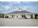 Community clubhouse exterior showcases classic architecture, lush landscaping, and ample parking at 383 Mikita Dr., Surfside Beach, SC 29575