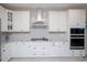 A stylish kitchen featuring white cabinets, a gray backsplash, and stainless steel appliances for a modern touch at 383 Mikita Dr., Surfside Beach, SC 29575