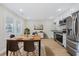Modern eat-in kitchen featuring stainless steel appliances, sleek white cabinets, wood flooring, and plenty of light at 409 2Nd Ave. S, Myrtle Beach, SC 29577