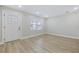 Bright living room featuring wood-look floors, a white front door, and natural light from the windows at 409 2Nd Ave. S, Myrtle Beach, SC 29577