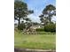 Cypress Bay community sign with lush landscaping, greenery, and mature trees under a cloudy blue sky at 4107 Pinehurst Circle # Dd-15, Little River, SC 29566