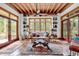 Cozy sunroom featuring large windows, terracotta tile floors, and rustic wooden accents at 4131 Gunter Lake Rd., Galivants Ferry, SC 29544