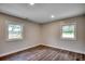 Sunlit bedroom with wood-look flooring, neutral walls, and windows overlooking the backyard at 4145 Highway 308, Galivants Ferry, SC 29544