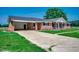 Quaint brick home with a concrete driveway and an attached carport and a well-manicured lawn at 4145 Highway 308, Galivants Ferry, SC 29544
