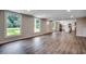 Open-concept living room featuring hardwood floors and large windows, flowing into a modern kitchen area at 4145 Highway 308, Galivants Ferry, SC 29544