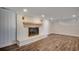 Spacious living room featuring a white brick fireplace, wooden mantel, and modern wood-look flooring at 4145 Highway 308, Galivants Ferry, SC 29544