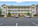Attractive multi-story condo building with ample parking spaces and well-kept landscaping and inviting stairwells at 4251 Hibiscus Dr. # 202, Little River, SC 29566
