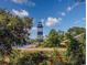 Picturesque view of a lighthouse surrounded by lush greenery and a serene landscape at 4430 Eastport Blvd. # L-11, Little River, SC 29566