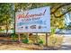 A weathered Welcome to Little River sign, advertising the Blue Crab Festival, surrounded by trees at 4430 Eastport Blvd. # L-11, Little River, SC 29566