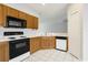 Bright kitchen with black and white appliances, light oak cabinets, and white tile floors at 4430-G Montrose Ln. # G, Myrtle Beach, SC 29579