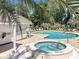 Community pool and hot tub with surrounding lounge chairs and lush landscaping on a sunny day at 4477 Little River Inn Ln. # 1802, Little River, SC 29566