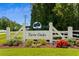Beautiful entrance to Twin Oaks, featuring a manicured garden and American flags at 450 Oaklanding Ln., Murrells Inlet, SC 29576