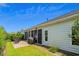 Home exterior with a brick patio, rocking chairs, screened porch, grill, and lush landscaping at 450 Oaklanding Ln., Murrells Inlet, SC 29576