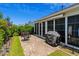 Brick patio with comfortable seating and a grill, adjacent to a sunroom, perfect for outdoor relaxation and entertaining at 450 Oaklanding Ln., Murrells Inlet, SC 29576