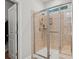Shower with light tile walls, a glass enclosure, rainfall shower head and bench seating at 450 Oaklanding Ln., Murrells Inlet, SC 29576