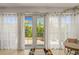Bright sunroom with white sheer curtains, tile floors, and a view of the outdoors providing a peaceful retreat at 450 Oaklanding Ln., Murrells Inlet, SC 29576