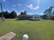 Backyard with a well-maintained lawn, mature trees, a small fenced yard, and a detached garage at 4637 Dogwood St., Loris, SC 29569