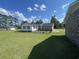 The backyard features a well-maintained lawn, mature trees, a small fenced yard, and a detached garage at 4637 Dogwood St., Loris, SC 29569