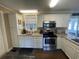 Modern kitchen with white cabinets, granite countertops, stainless steel appliances, and hardwood floors at 4637 Dogwood St., Loris, SC 29569