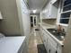This laundry room has tile flooring, white cabinets and a double stainless steel sink with a window at 4637 Dogwood St., Loris, SC 29569
