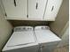 Laundry room with white washer and dryer, with white cabinets above and tiled flooring at 4637 Dogwood St., Loris, SC 29569