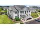Exterior elevation of two-story condo with green shutters, vinyl siding, and white columns at 4924 Pond Shoals Ct. # 201, Myrtle Beach, SC 29579