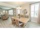 Open-concept dining area with a wood table, stylish chandelier, and seamless flow to the living room at 5059 Sundrop Ln., Little River, SC 29566
