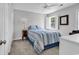 Bright bedroom featuring a cozy bed with blue accents, complemented by a sunny window with shuttered blinds at 521 Bay Drive Ext., Garden City Beach, SC 29576