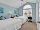 Guest bedroom with vaulted ceilings and two twin beds, complemented by soft blue decor and a sunny window at 521 Bay Drive Ext., Garden City Beach, SC 29576