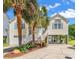 Charming two-story coastal home with mature palms, a garage, and elevated living, offering a glimpse of the waterway at 521 Bay Drive Ext., Garden City Beach, SC 29576