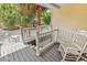 Inviting front porch with rocking chair and view of lush green palm trees at 521 Bay Drive Ext., Garden City Beach, SC 29576