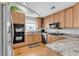 Well-lit kitchen features wood cabinets, granite countertops, stainless steel appliances, and recessed lighting at 521 Bay Drive Ext., Garden City Beach, SC 29576