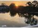 Sunrise view with colorful sky reflecting on the water, and the outline of trees at 521 Bay Drive Ext., Garden City Beach, SC 29576