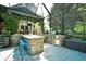Outdoor kitchen area with stone counter, grill, and seating, overlooking a lush backyard at 5718 Herring Gull Circle, North Myrtle Beach, SC 29582