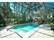 Enclosed pool with tiled deck, steps, mature landscaping, and clear blue water at 5718 Herring Gull Circle, North Myrtle Beach, SC 29582