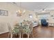 Bright dining area with a chandelier and seating for four adjacent to the living room at 613 S 2Nd Ave. # 21D, North Myrtle Beach, SC 29582